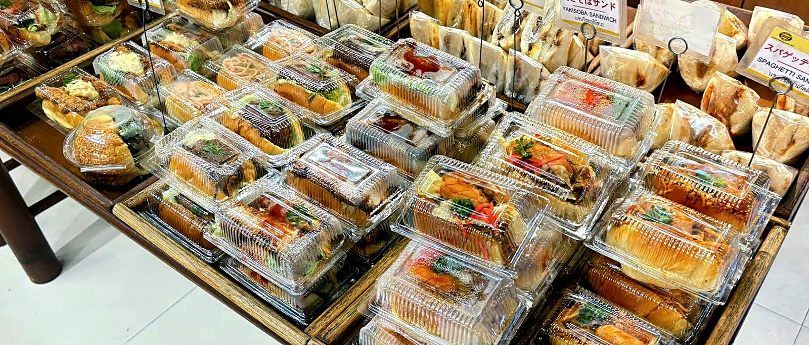 Tables of wrapped sandwiches and pastries — Custard Nakamura, Japanese bakery Bangkok